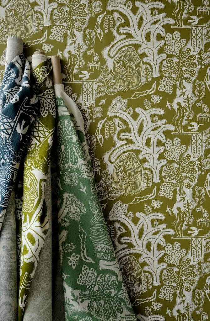 green white wallpaper with fabric rolls leaning against wall