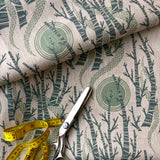 Fabric with tree pattern, scissors, and measuring tape on top