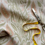 Fabric with a floral pattern, scissors, and measuring tape on top