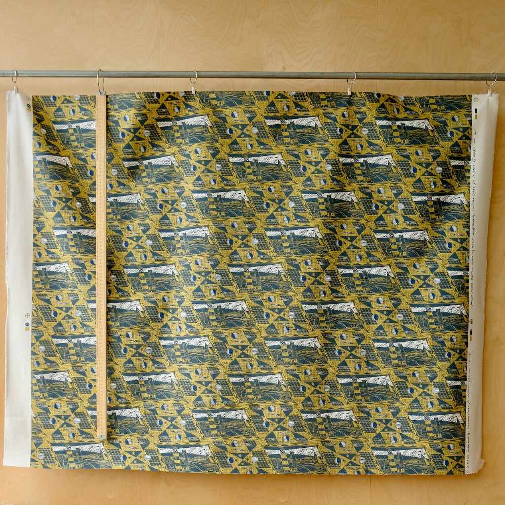 navy, white and yellow printed fabric in front of a plywood board