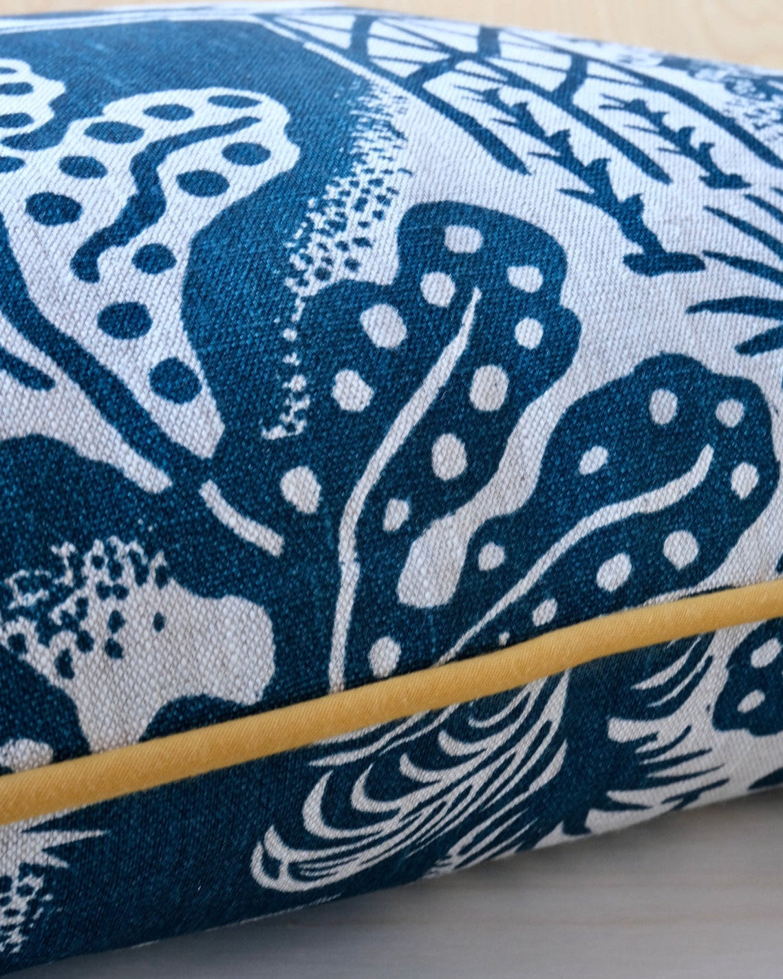 Cushion with blue screen printed design with ochre trim.