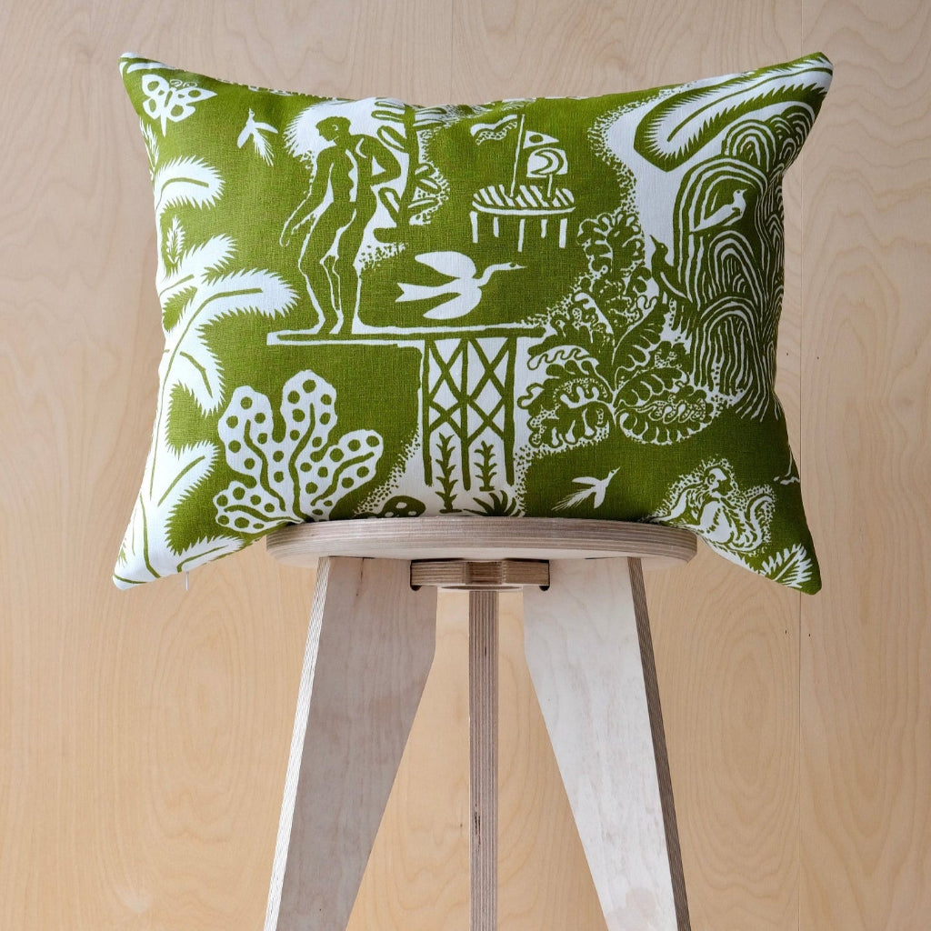 Green and white patterned cushion on a wooden stool against a light wood panel background