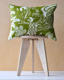 Green and white patterned cushion on a wooden stool against a light wood panel background