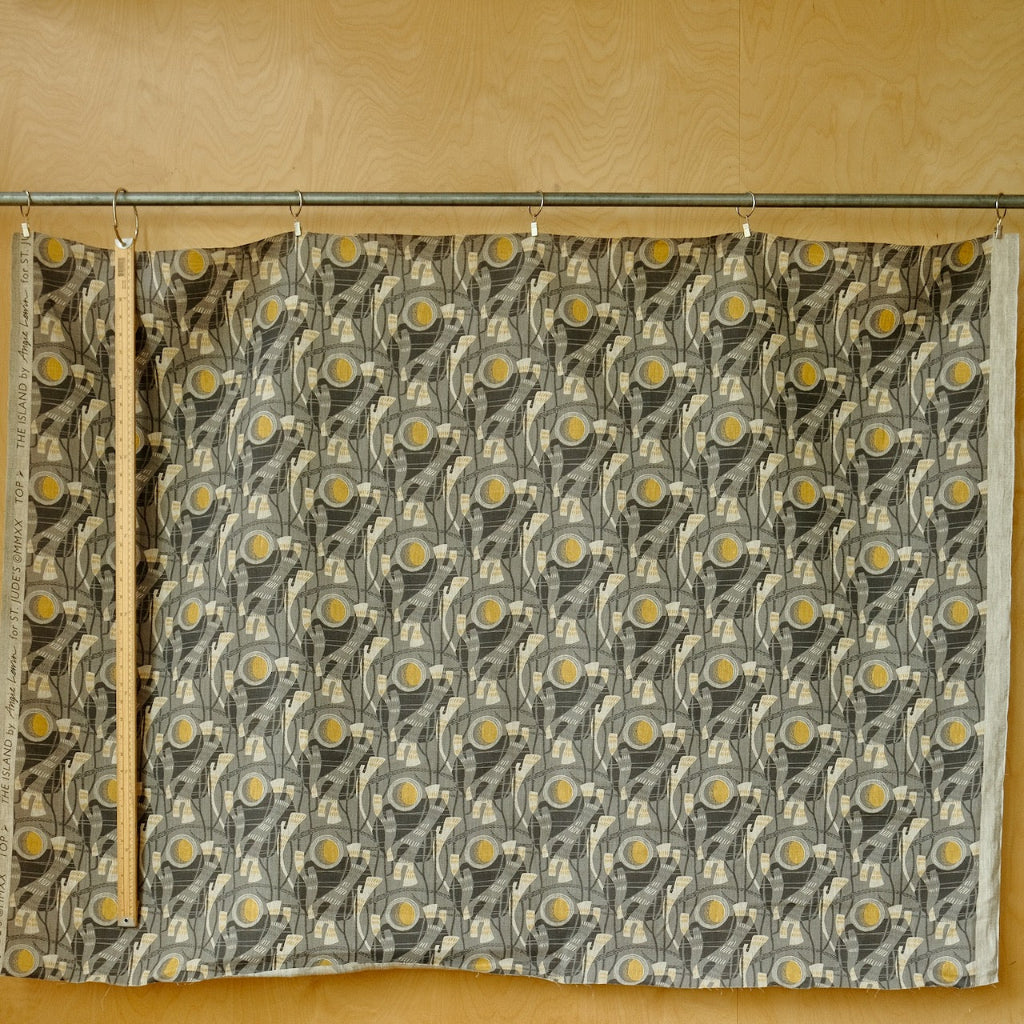 Grey fabric with a pattern of circles and lines on a yellow background
